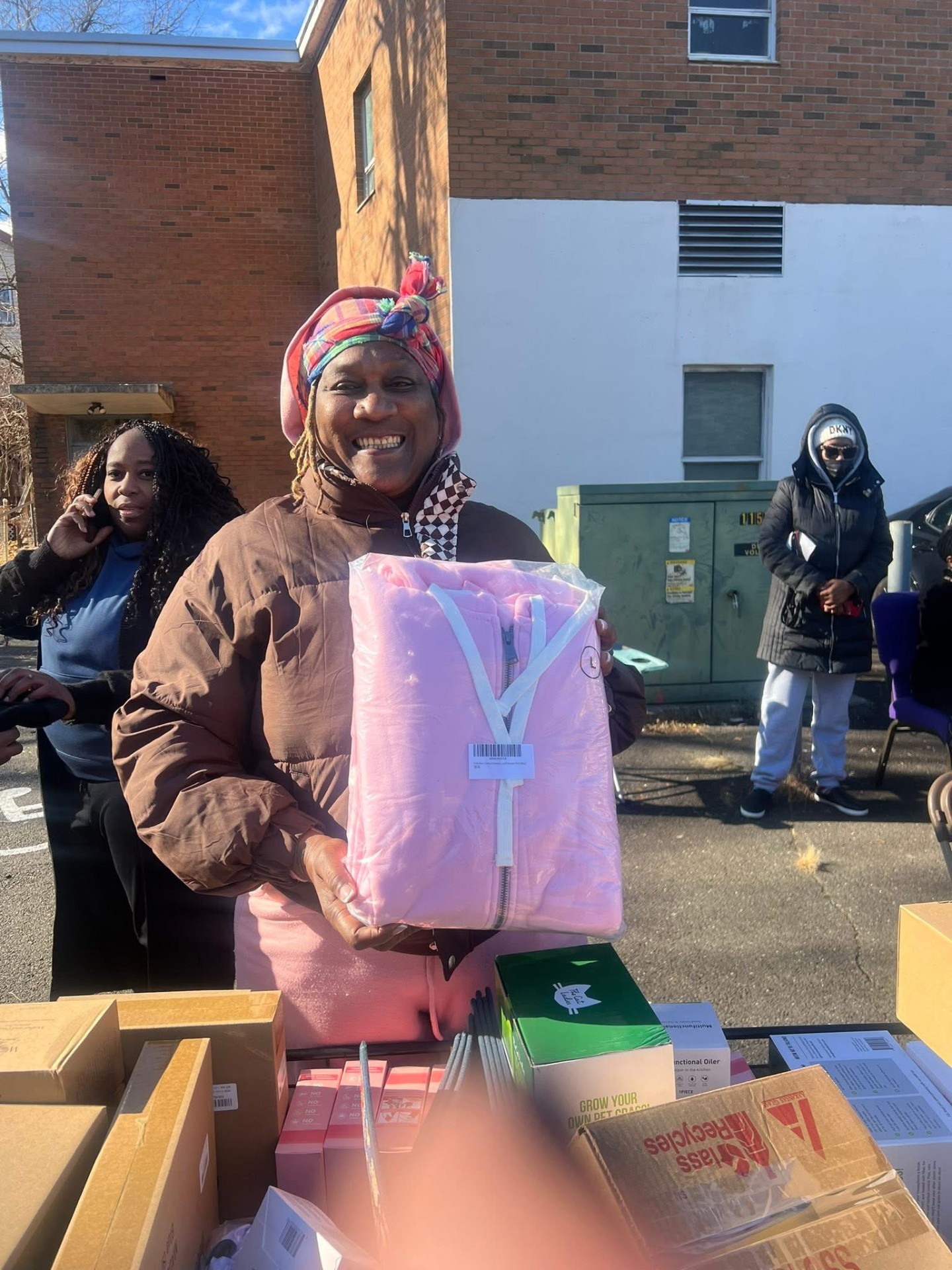 Community member receiving a winter coat at Village outreach event